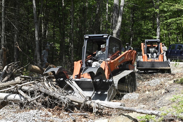 Photo of the 145th Civil Engineers using clawed vehicles clearing fallen trees from a pathway in the woods of North Carolina Photo of the 145th Civil Engineers using clawed vehicles clearing fallen trees from a pathway in the woods of North Carolina
