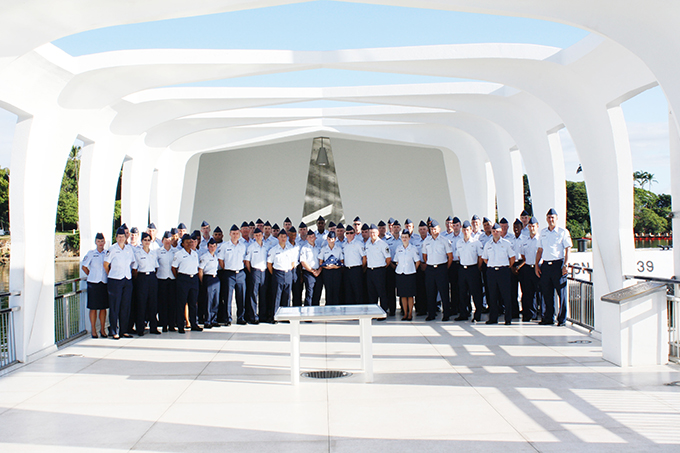 Photo of the 145th Air Traffic Control Squadron standing in dress uniform at a memorial in Hawaiii