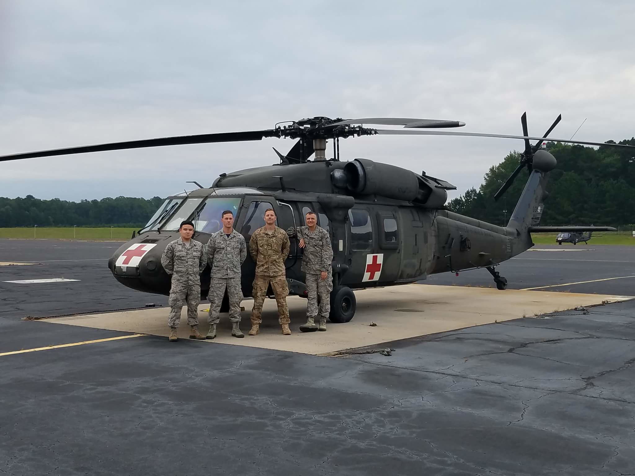 A photo of members from the 156th Weather flight standing in front of a helicopter. 