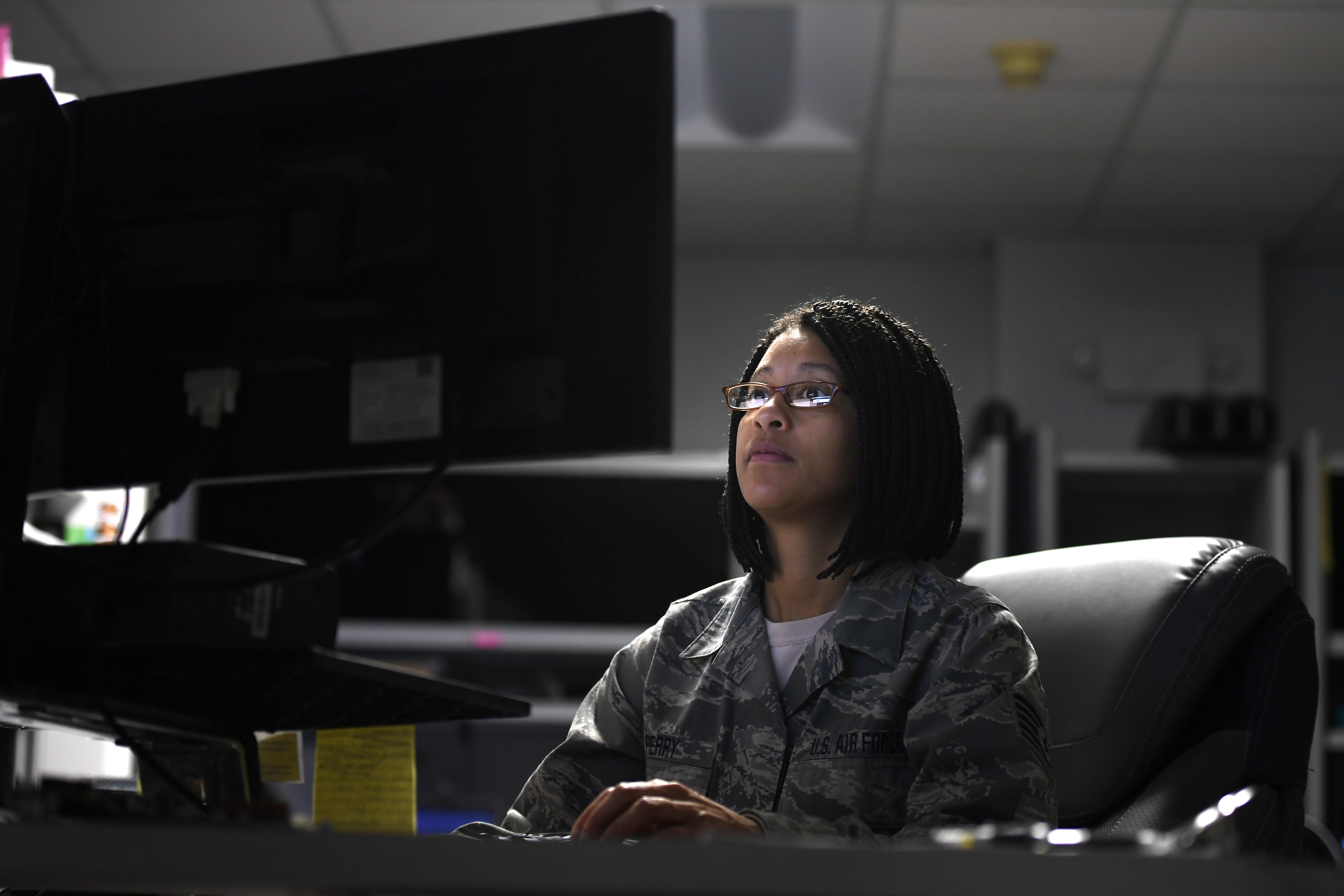 photo of a 145th Airlift Wing Communication flight Airman looking at a computer screen in her office. 