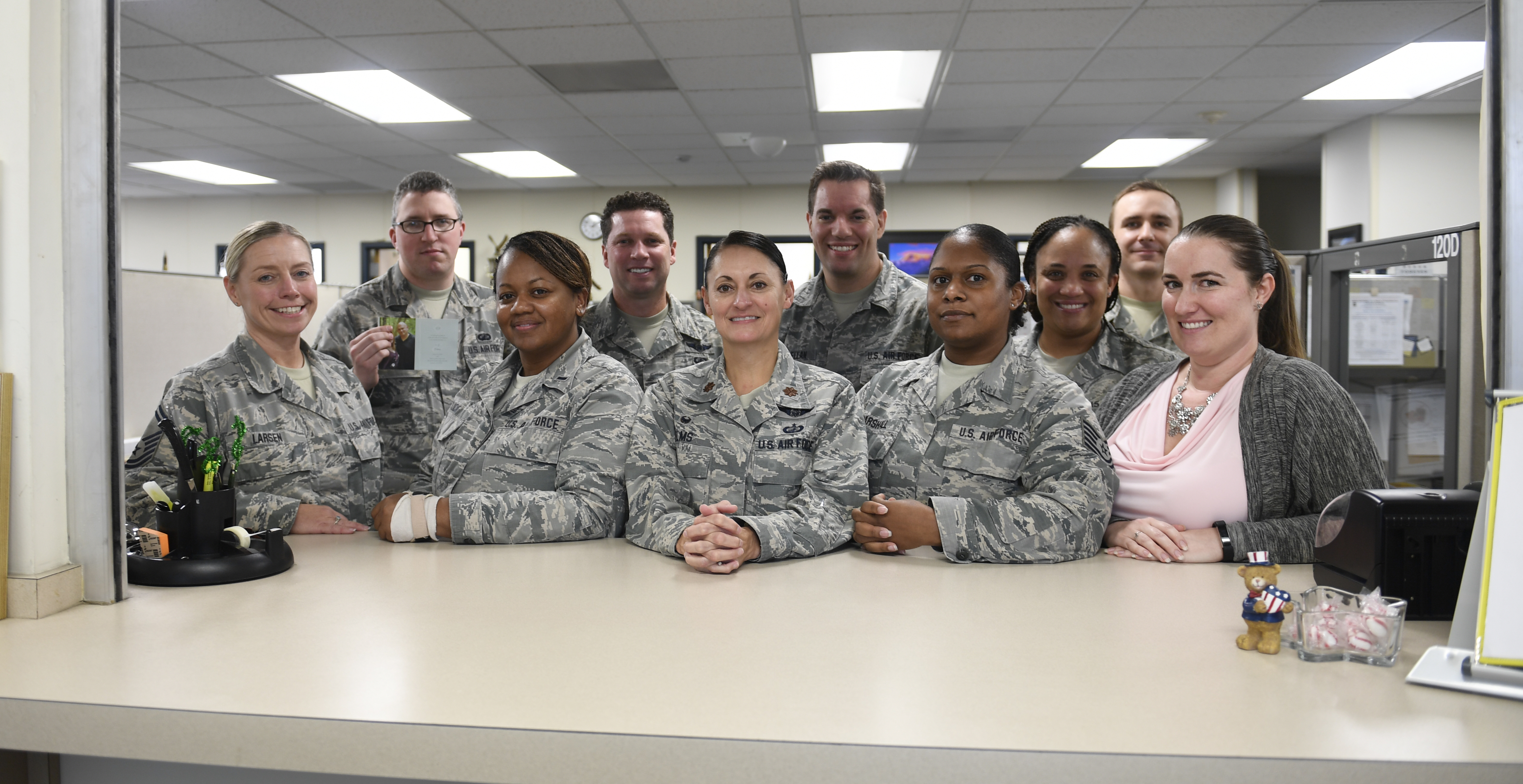 Photo of the 145th Airlift Wing Finance team standing at the help window of the finance office. 