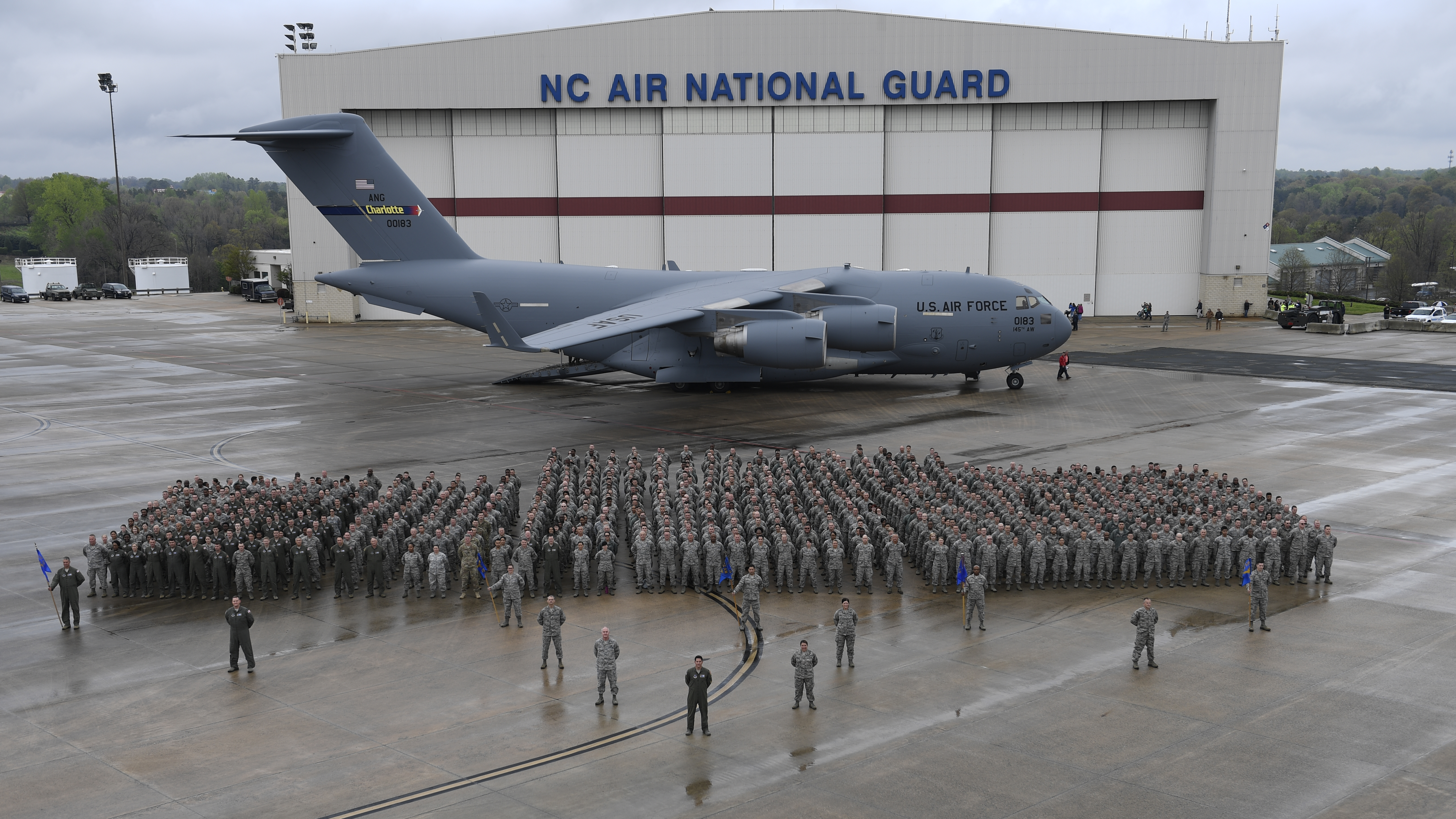 A mass wing photo of the 145th Airlift Wing in front of a C-17 in front of the Wing hanger. 